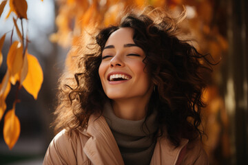 Portrait of beautiful young woman with curly hair outdoors on autumn day