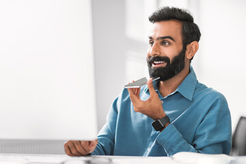 Businessman talking on speakerphone at his desk