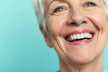 Smiling elderly person with smooth white teeth implants. Close up portrait of female mouth on pastel blue background, banner with copy space. Positive senior woman - obrazy, fototapety, plakaty