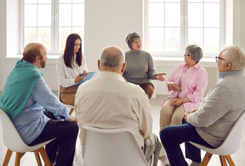 Old people communicating at group therapy meeting. Several male and female senior citizens sharing...