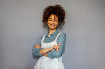 Young black woman wearing beige apron isolated on grey background with copy space.