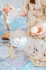 girl holding bath bombs in her hand in pink, cream and white colours on a blue background