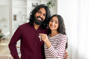 Portrait of happy young indian couple showing key from house