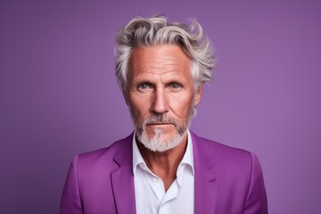 Portrait of a senior man with grey hair and beard. Isolated on purple background.