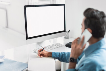 Professional businessman multitasking with phone and notes at desk