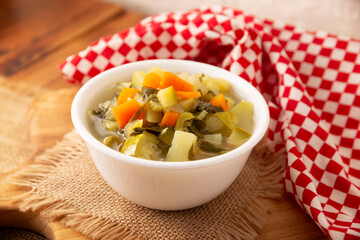 Homemade fresh vegetable soup, easy recipe made with chopped vegetables, carrot, celery, pumpkin, spinach, chayote and other ingredients, healthy dish popular in many countries.