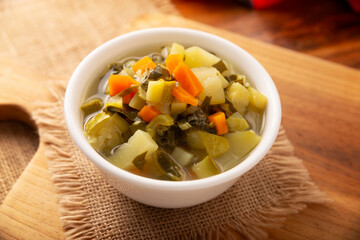 Homemade fresh vegetable soup, easy recipe made with chopped vegetables, carrot, celery, pumpkin, spinach, chayote and other ingredients, healthy dish popular in many countries.