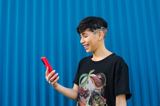 Androgynous rocker woman on the street using her smartphone