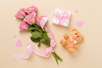 Pink roses with hearts and gifts on color background, top view. Valentines day concept