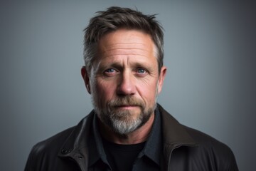 Portrait of a man with a beard on a gray background.