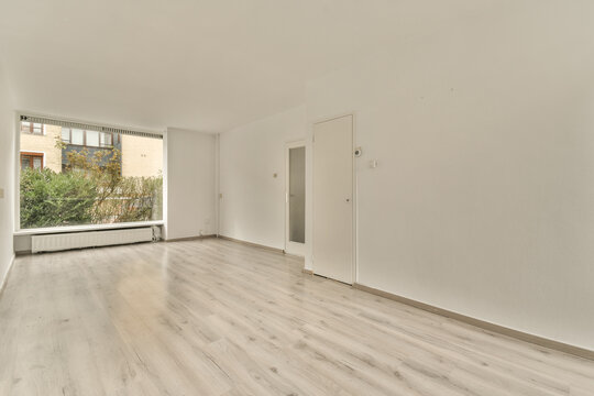 a living room with white walls and a window