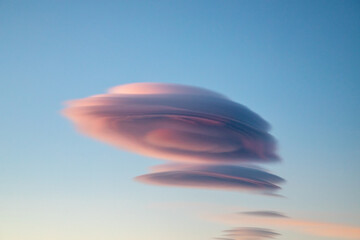 Lenticular clouds at dusk with pink and grey hues