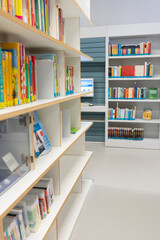 A room with bookshelves. White bookshelves with lots of books.