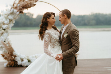 the first wedding dance of the bride and groom on the pier near the river