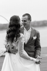 the first wedding dance of the bride and groom on the pier near the river