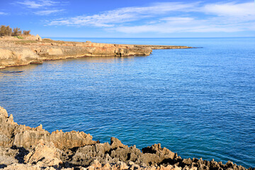 Fototapeta na wymiar The most beautiful Apulian coast in Italy: Cala Corvino. Typical coastline near Monopoli whith trullo house: high and rocky coast characterized by small sandy coves with cliffs and rocky arches.