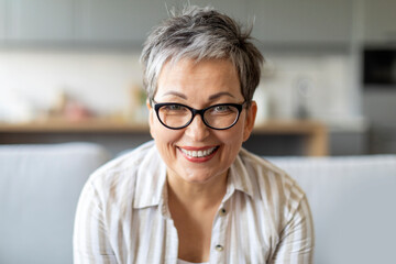 Closeup portrait of happy senior woman with stylish glasses and warm smile