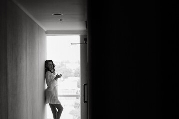 brown-haired girl in the morning in a bathrobe in the hotel corridor with