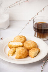 Plate with tasty choux dessert on light background
