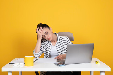 Tired businesswoman, portrait of caucasian tired businesswoman. Sit at office desk, hold forehead. Work on laptop and paper documents. Feeling sick at work. Office worker lifestyle concept image.