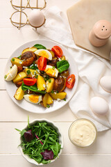 Composition with tasty potato salad on light wooden background
