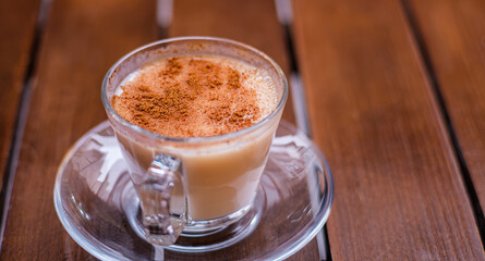 Turkish traditional hot drink salep on wooden background. Sahlep served with cinnamon on top in Turkey cafe. Selective focus.