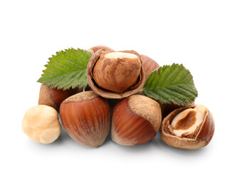 Shelled hazelnuts with leaves on white background