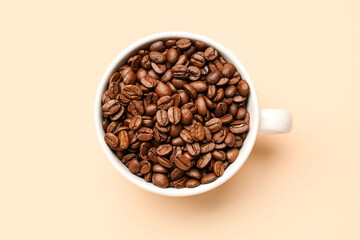 Cup with aromatic coffee beans on pale yellow background