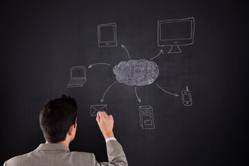 a man drawing a diagram off a network on a blackboard