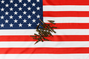 Bullets for firearms, combat army cartridges on the American flag, top view.