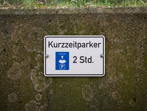 Kurzzeitparker (short-term parkers) sign at a parking lot. It allows to park the car for two hours only. Signage for the car drivers in Germany on a wall.