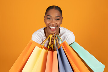 Portrait of happy customer black woman holding many shopper bags