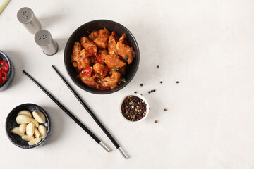 Tasty sweet and sour chicken in bowl with spices on white background