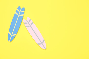 Mini colorful surfboards on yellow background