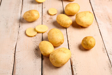 Raw baby potatoes on white wooden background