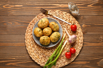 Fototapeta na wymiar Plate of boiled baby potatoes with dill and green onion on wooden background