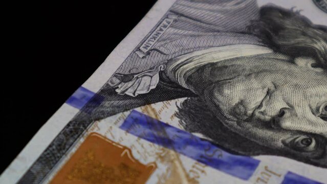 An macro level closeup video of the 100 US Dollar banknotes rotating on an automatic table while focusing the photo of president