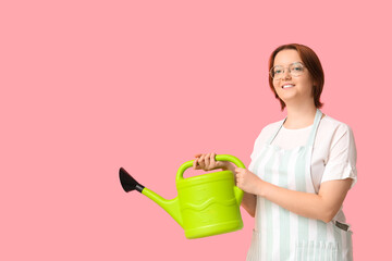 Smiling woman with watering can on pink background