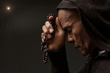 man praying to god with hands together on grey black background stock image stock photo	