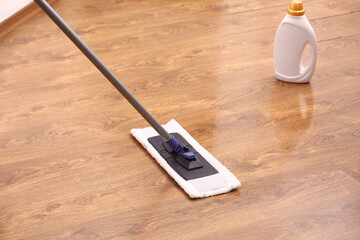Cleaning of wooden laminate floor with mop and detergent