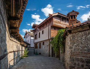 Fototapeta na wymiar Old narrow street in old bulgarian town. Summer cityscape in Bansko ski resort, Bulgaria.