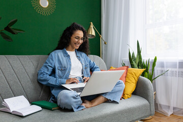 Young beautiful businesswoman freelancer working from home remotely, successful joyful Latin...