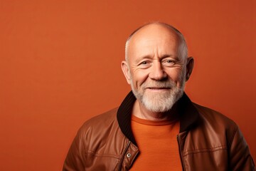 Portrait of a smiling senior man. Isolated over orange background.