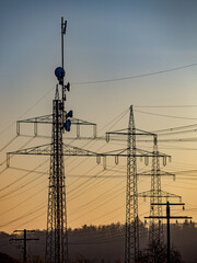 Strommasten und Sendemast in der Abendsonne