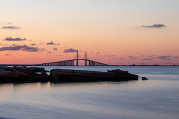 Fototapeta na wymiar Sunset hues over the Sunshine Skyway Bridge with calm waters.