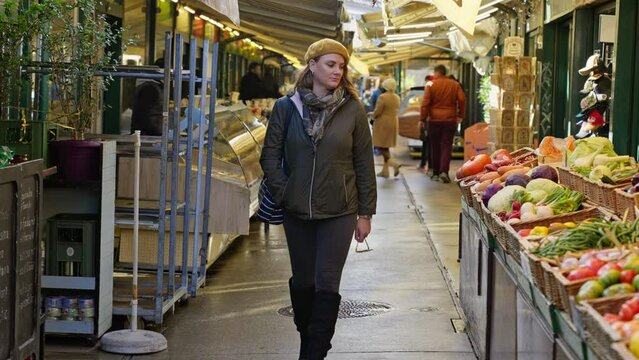 Person walking next to food booths in an open air markets on a cold day, Vienna, Austria