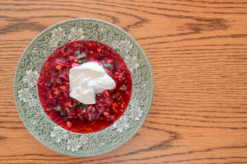 A traditional dish of Ukrainian cuisine - borsch. Soup with beets, meat, potatoes and beans. Served with sour cream and garlic. Close-up