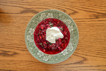 A traditional dish of Ukrainian cuisine - borsch. Soup with beets, meat, potatoes and beans. Served with sour cream and garlic. Close-up