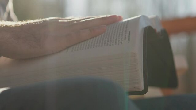 Macro shot of hands studying scripture and holding the Bible 