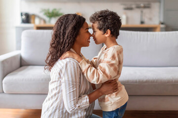 Cheerful black mother and little son sharing tender nose-to-nose moment at home
